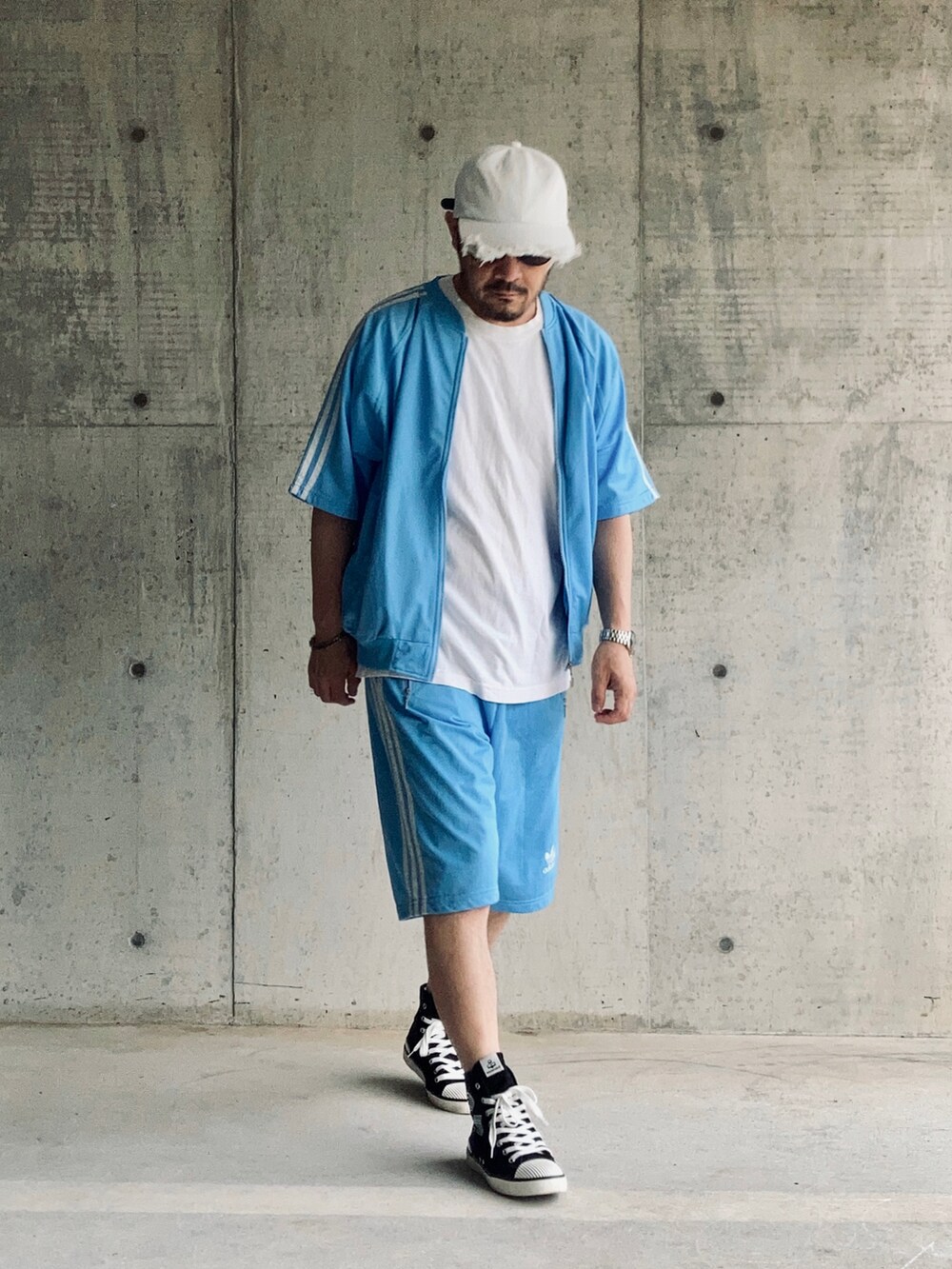 ブルー系のセットアップ、ホワイト系のTシャツ/カットソー、ブラック系のスニーカーを着用したメンズの夏コーディネートの3枚目の写真