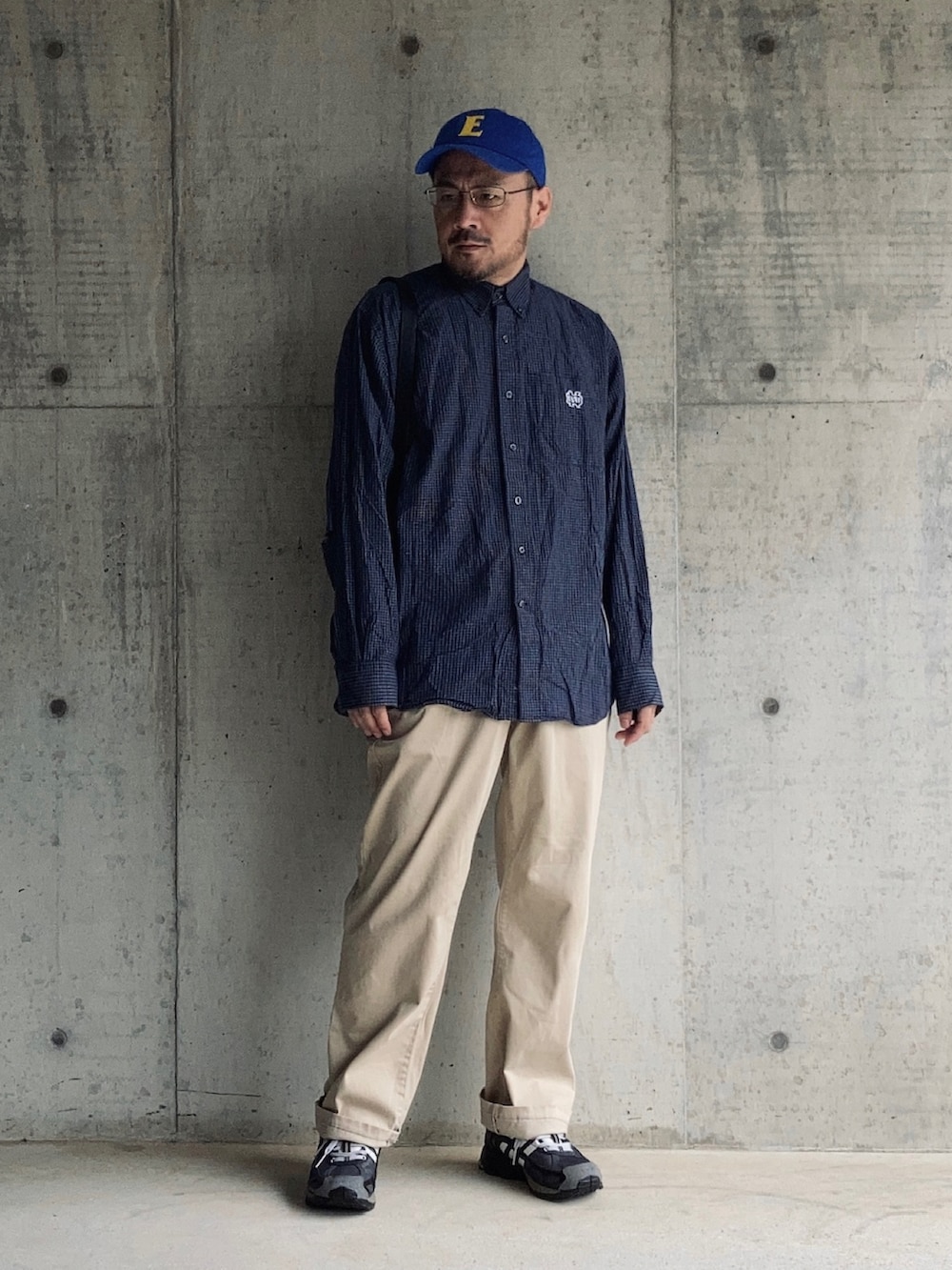 ブルー系のシャツ/ブラウス、ベージュ系のチノパンツ、ブラック系のスニーカーを着用したメンズの秋コーディネートの4枚目の写真