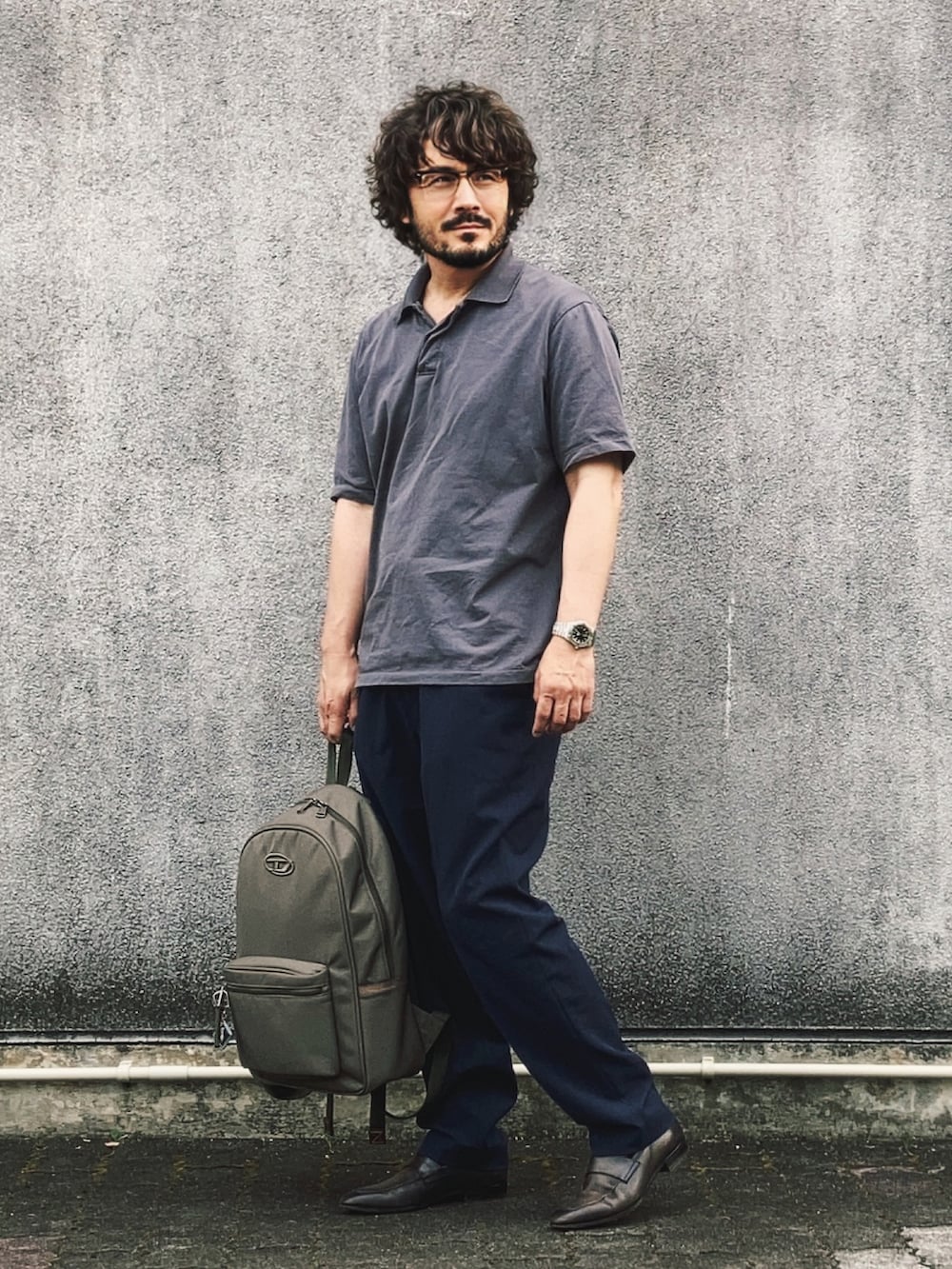 グレー系のポロシャツ、ブルー系のその他パンツ、グリーン系のローファーを着用したメンズの夏コーディネートの3枚目の写真