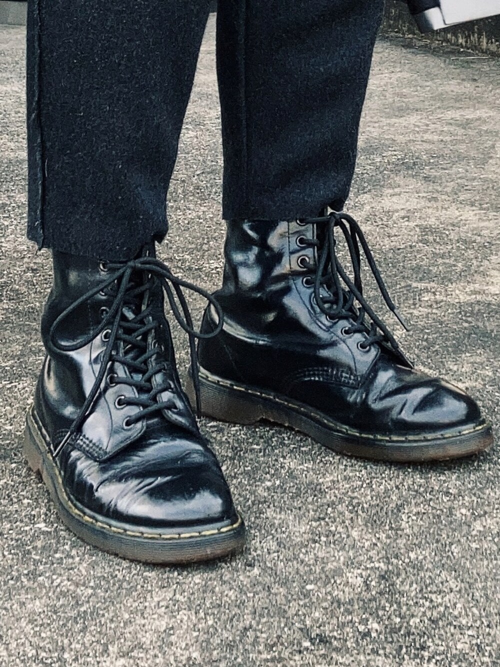 シルバー系のノーカラーコート、ブラック系のスラックス、ブラック系のブーツを着用したメンズの冬コーディネートの4枚目の写真