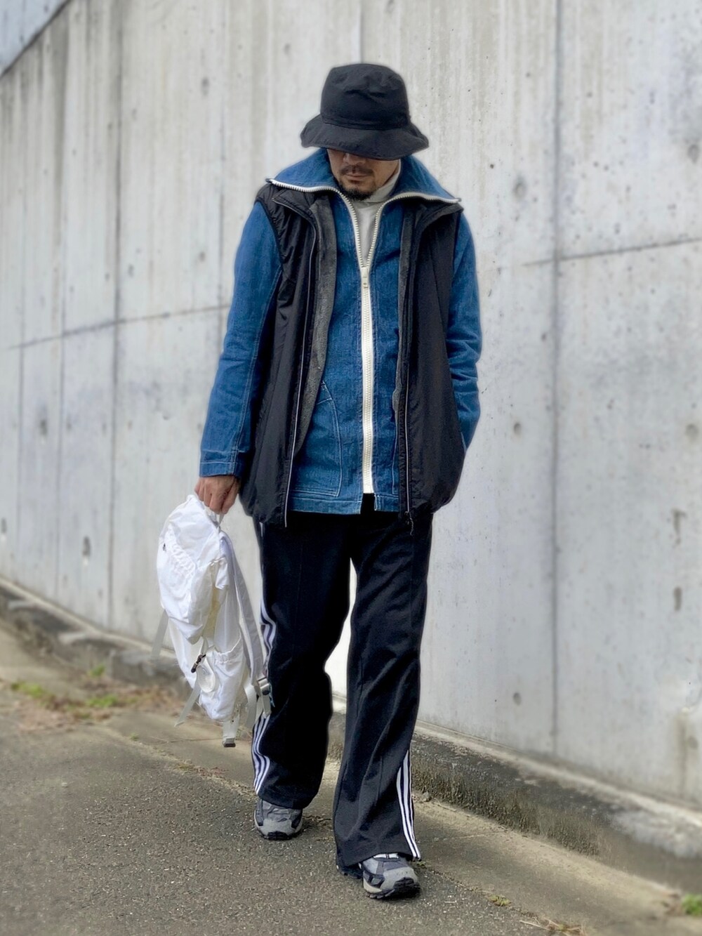 ホワイト系のTシャツ/カットソー、ブルー系のデニムジャケット、ブラック系のベストを着用したメンズの冬コーディネートの4枚目の写真
