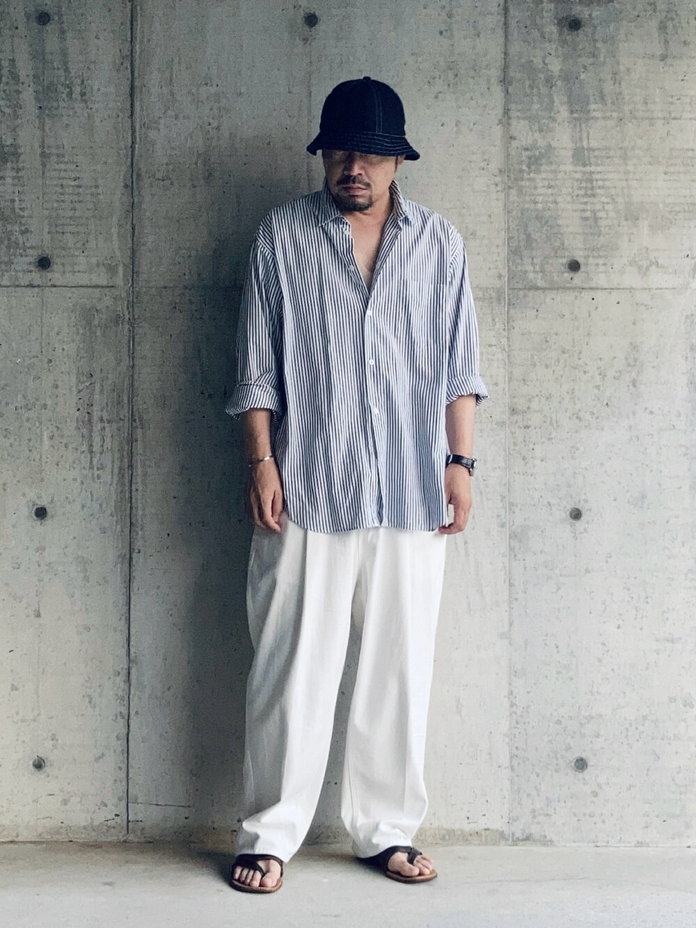 ホワイト系のスラックス、ブルー系のシャツ/ブラウス、ブラウン系のサンダルを着用したメンズの夏コーディネートの3枚目の写真