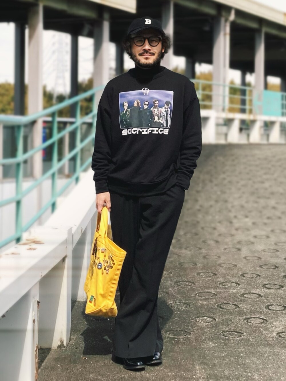 ブラック系のスウェット、ブラック系のスラックス、ブラック系のブーツを着用したメンズの春コーディネートの2枚目の写真