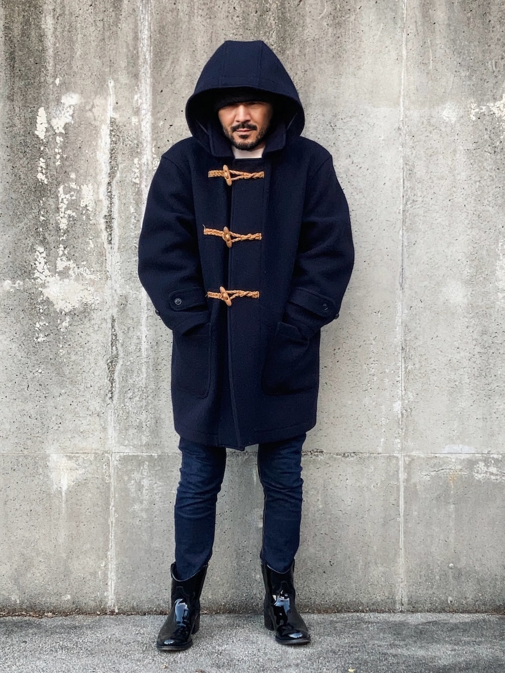 ブラック系のテーラードジャケット、ブルー系のダッフルコート、ブルー系のデニムパンツを着用したメンズの秋コーディネートの3枚目の写真