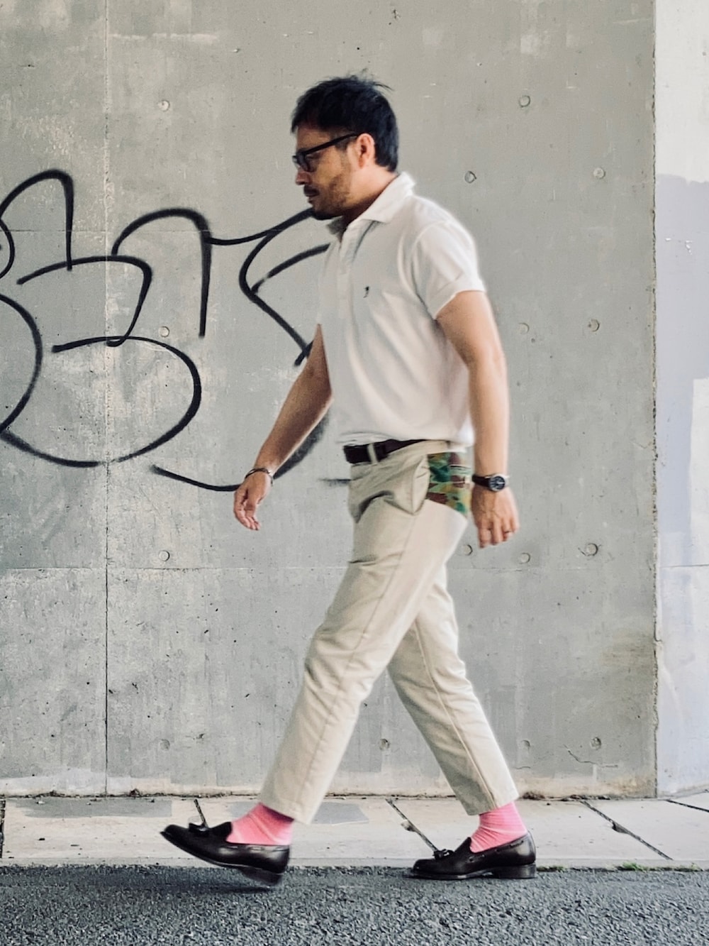 ホワイト系のポロシャツ、ベージュ系のチノパンツ、ブラウン系のローファーを着用したメンズの春コーディネートの2枚目の写真