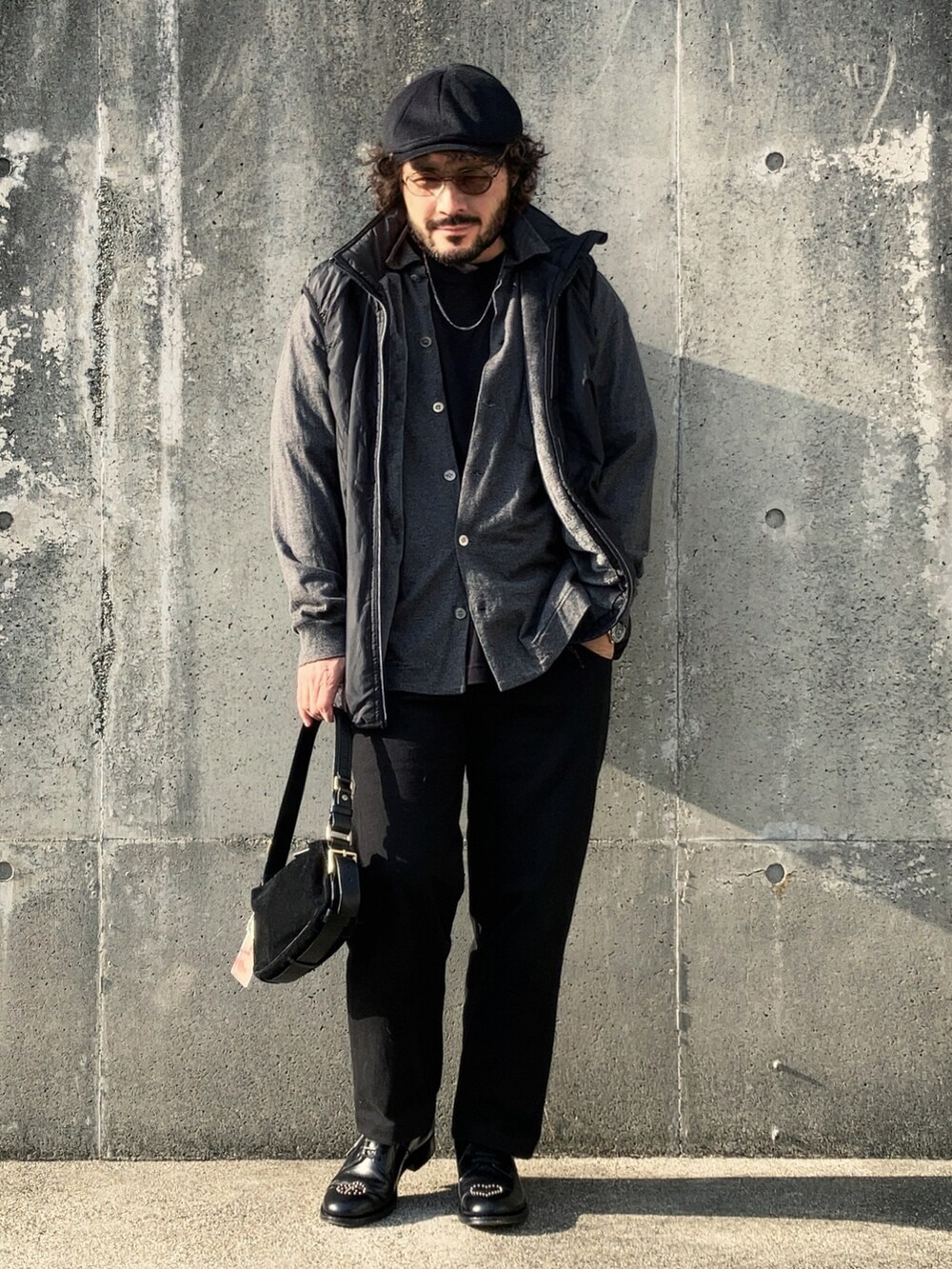 グレー系のシャツ/ブラウス、ブラック系のベスト、ブラック系のパンツを着用したレディースの秋コーディネートの2枚目の写真