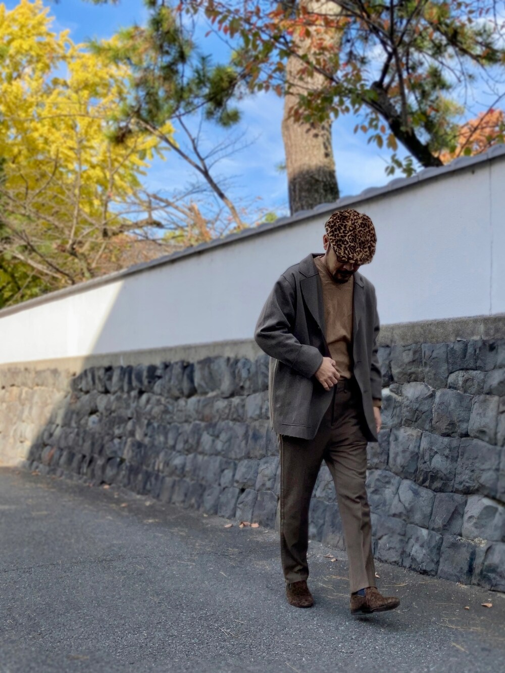 ブラウン系のニット/セーター、ブラウン系のテーラードジャケット、グリーン系のスラックスを着用したメンズの秋コーディネートの4枚目の写真