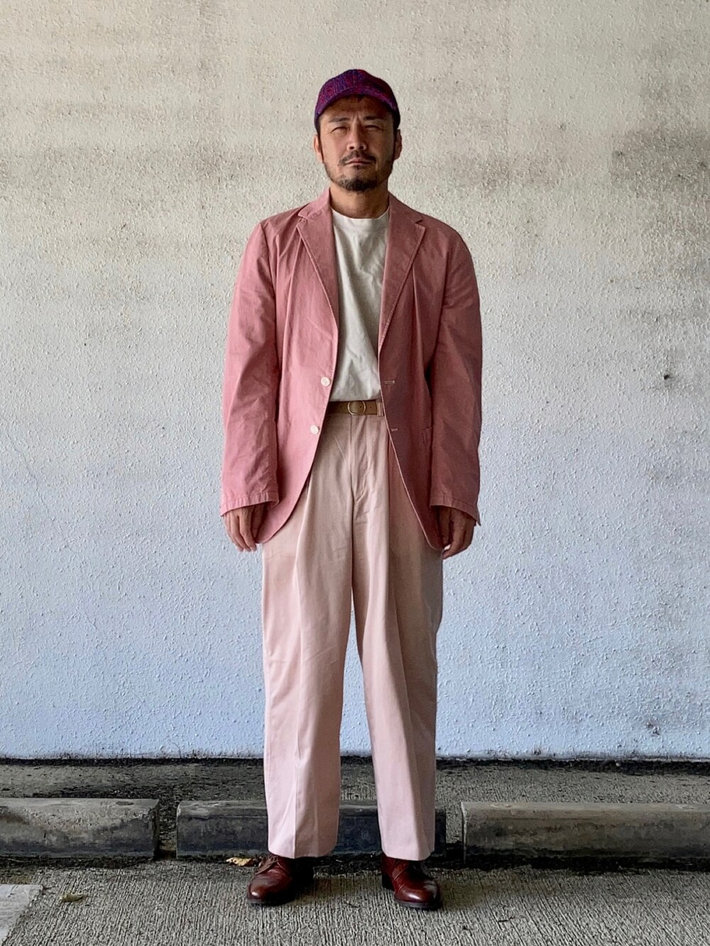 グレー系のTシャツ/カットソー、ピンク系のテーラードジャケット、ピンク系のスラックスを着用したメンズの秋コーディネートの3枚目の写真