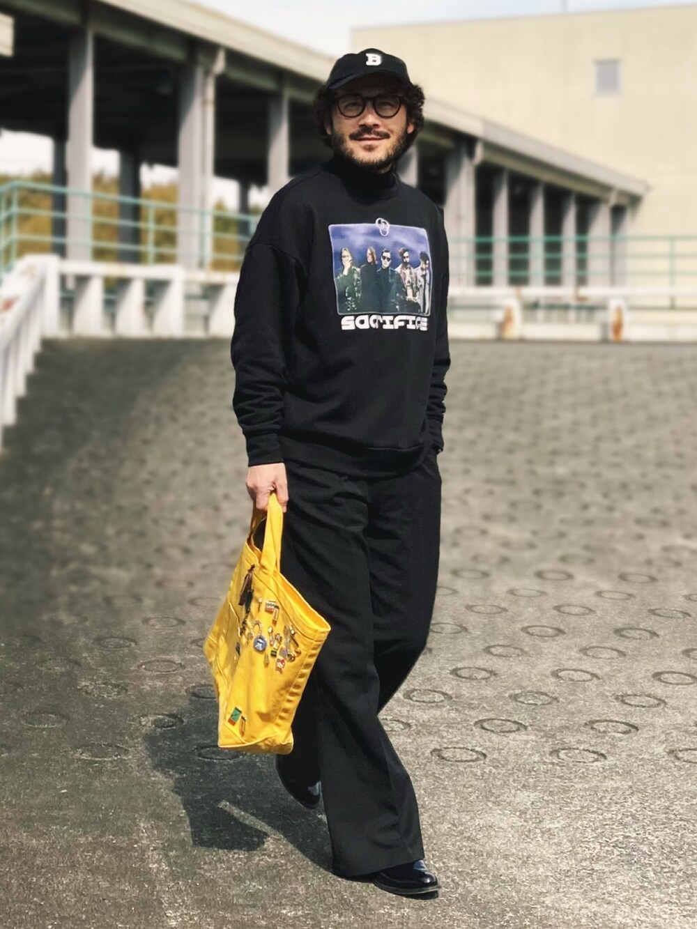 ブラック系のスウェット、ブラック系のスラックス、ブラック系のブーツを着用したメンズの春コーディネートの3枚目の写真