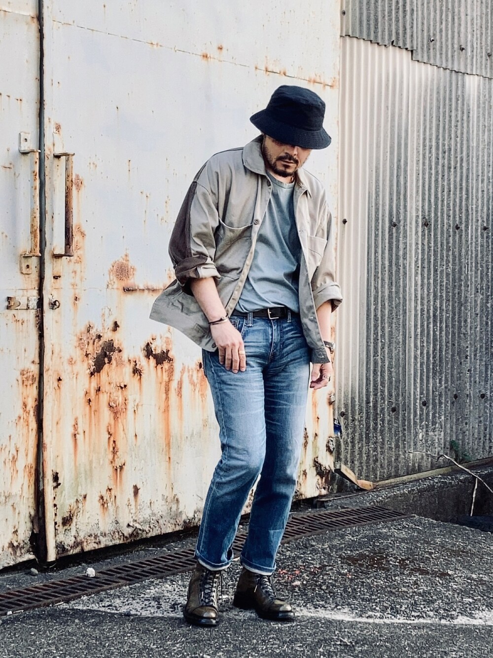 グリーン系のTシャツ/カットソー、ベージュ系のその他アウター、ブルー系のデニムパンツを着用したメンズの春コーディネートの2枚目の写真