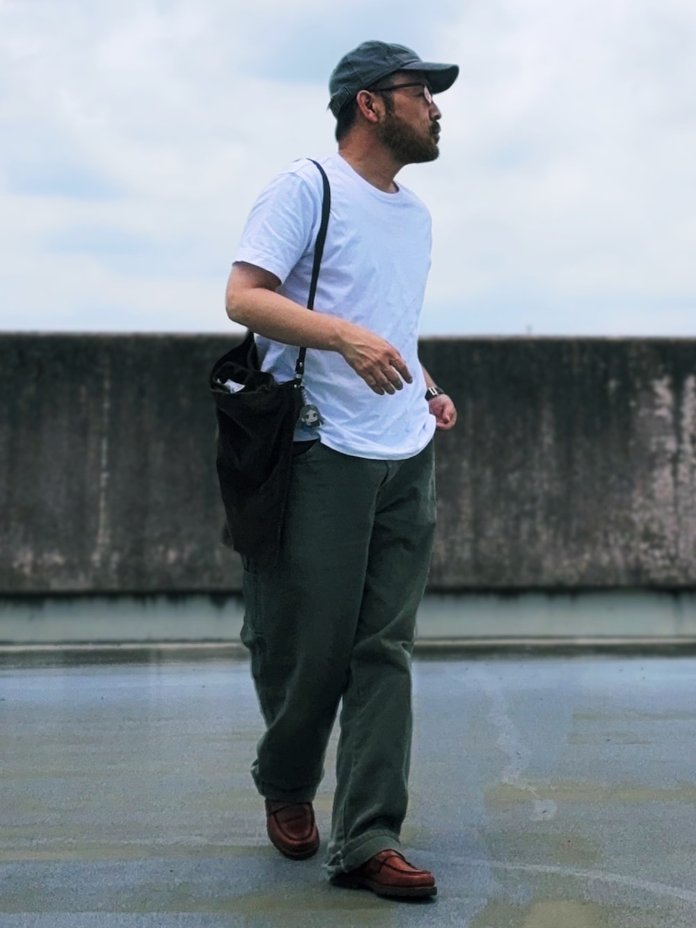 ホワイト系のTシャツ/カットソー、グリーン系のその他パンツ、ブラウン系のトートバッグを着用したメンズの夏コーディネートの2枚目の写真