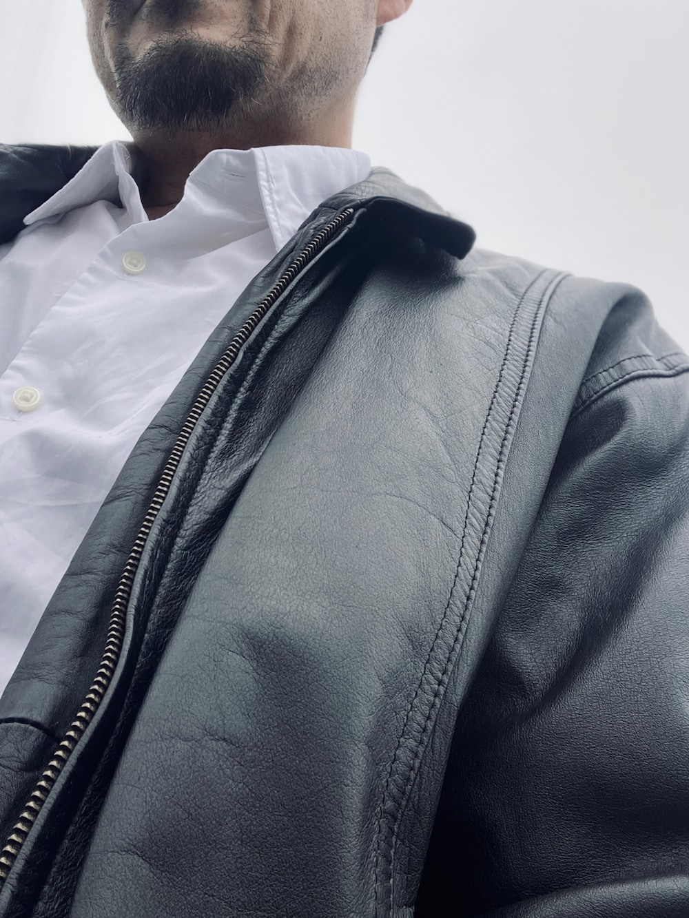 ホワイト系のシャツ/ブラウス、ブラック系のブルゾン、ブルー系のデニムパンツを着用したメンズの春コーディネートの5枚目の写真