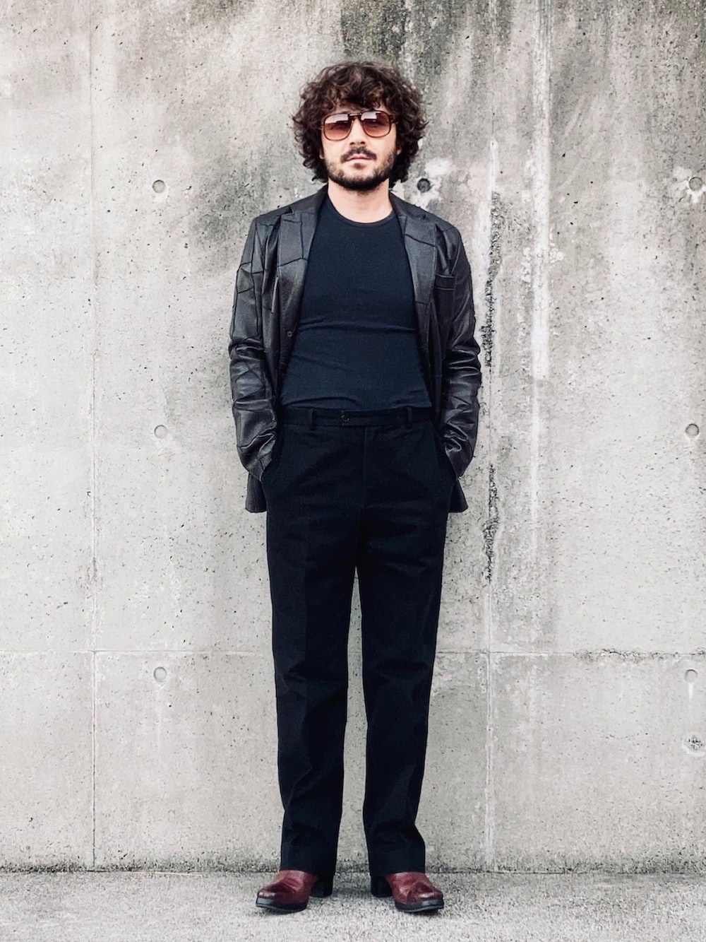 ブラウン系のテーラードジャケット、ブラック系のスラックス、レッド系のブーツを着用したメンズの秋コーディネートの2枚目の写真