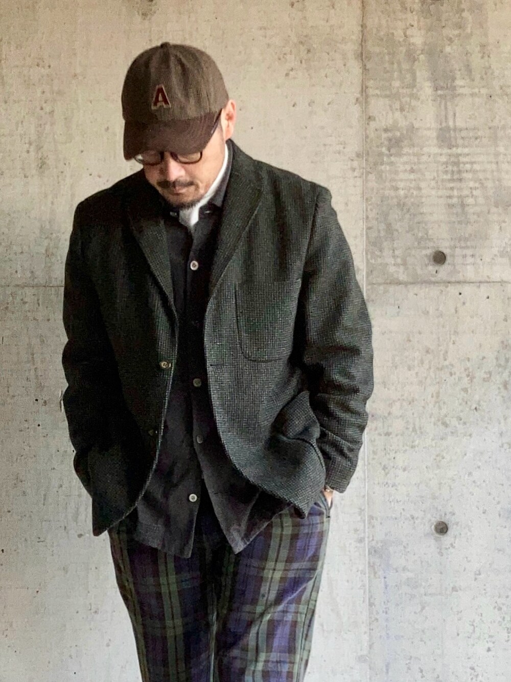 グレー系のテーラードジャケット、グリーン系のチノパンツ、ブラック系のスニーカーを着用したメンズの秋コーディネートの4枚目の写真