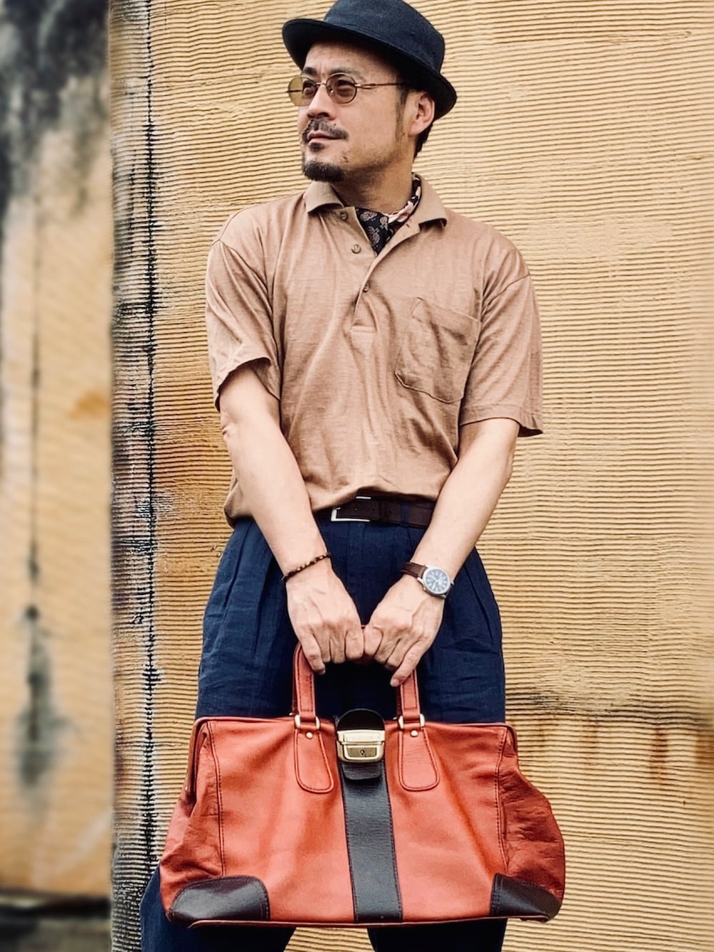 ブラウン系のポロシャツ、ブラウン系のドレスシューズ、ブラウン系のボストンバッグを着用したメンズの夏コーディネートの5枚目の写真