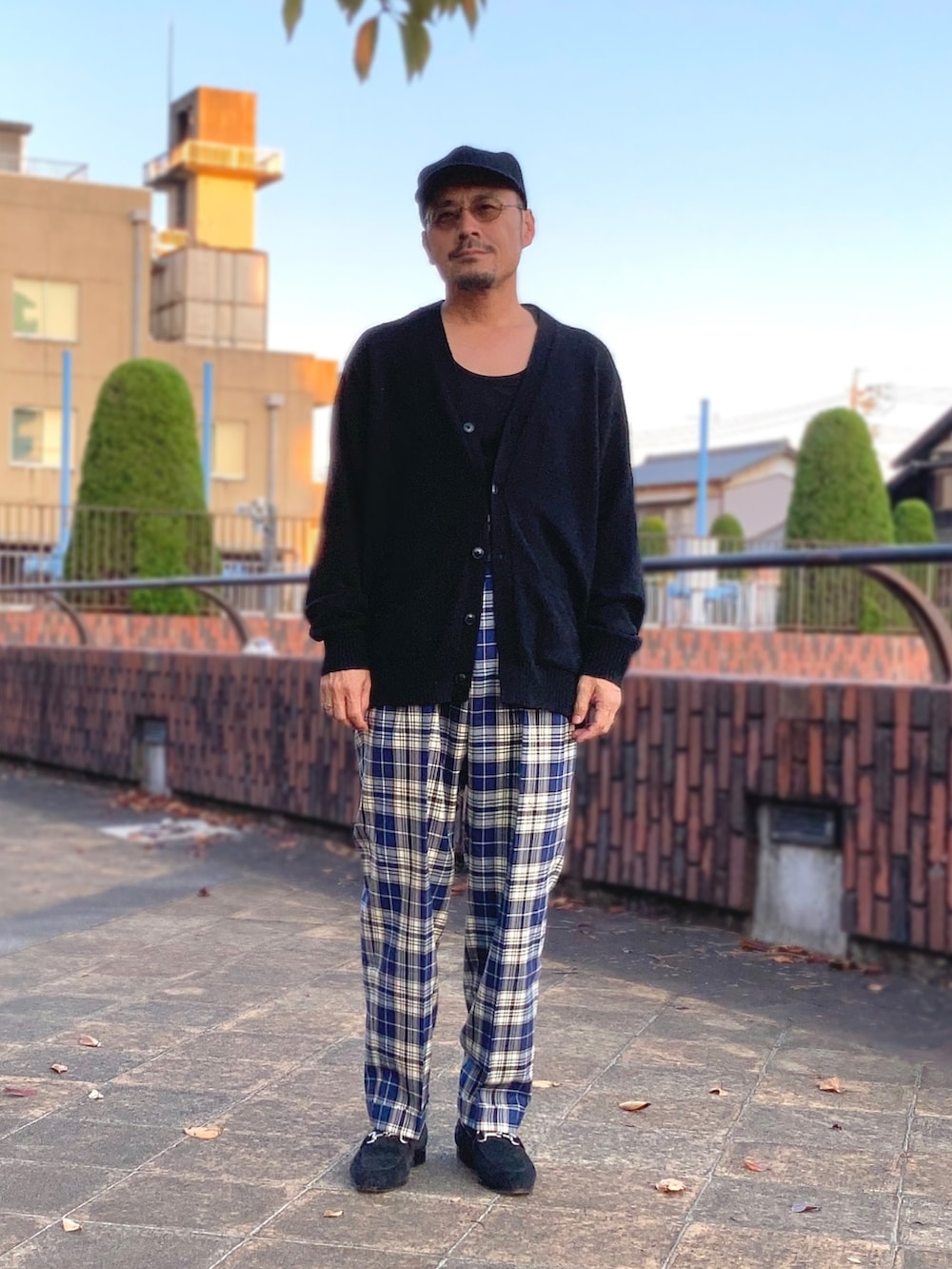 ブラック系のタンクトップ、ブラック系のカーディガン/ボレロ、ブルー系のスラックスを着用したメンズの秋コーディネートの2枚目の写真