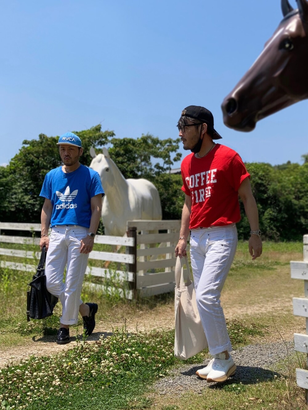 レッド系のTシャツ/カットソー、ブルー系のTシャツ/カットソー、ホワイト系のデニムパンツを着用したメンズの春コーディネートの2枚目の写真