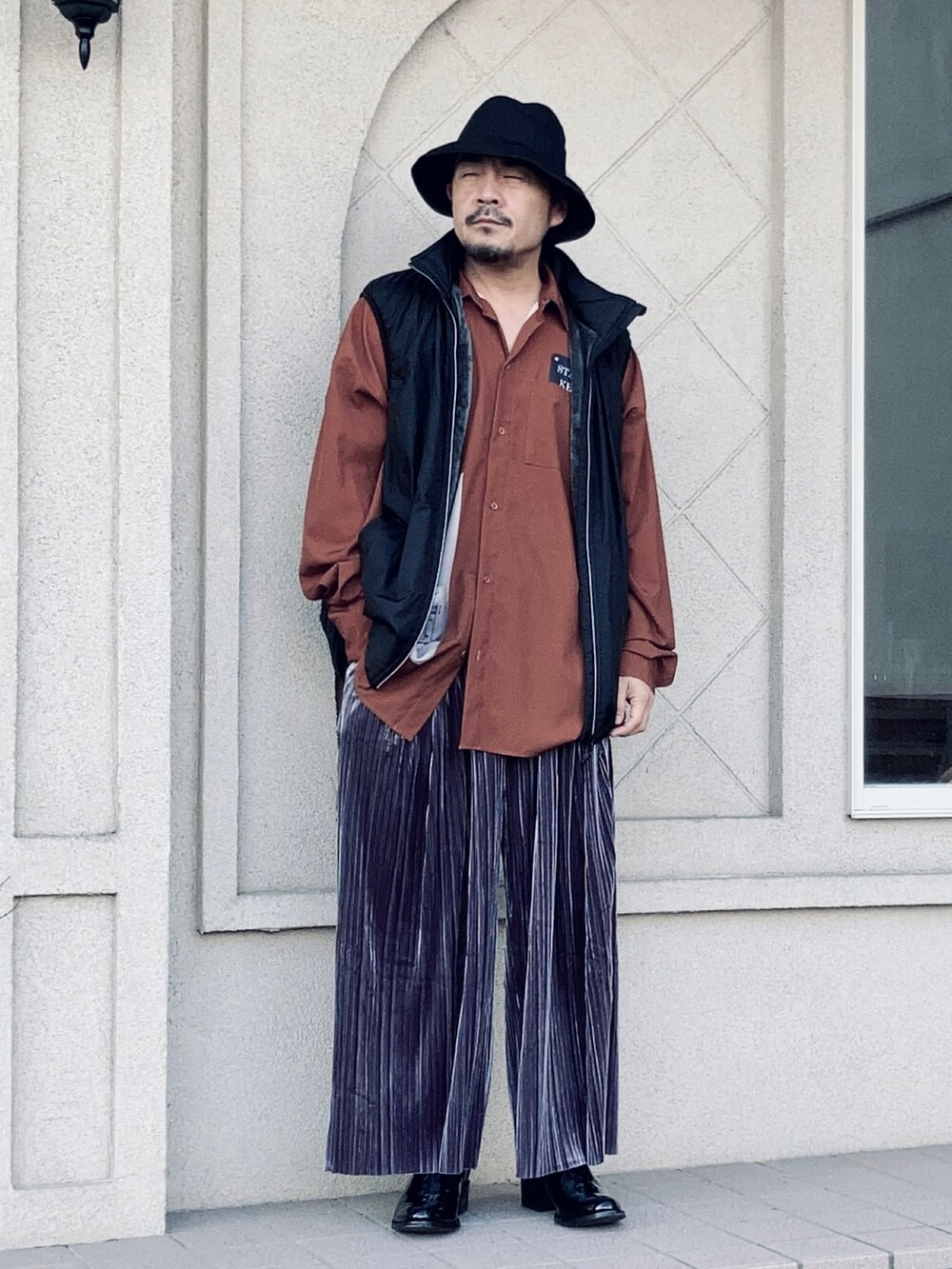 オレンジ系のシャツ/ブラウス、ブラック系のベスト、グレー系のその他パンツを着用したメンズの秋コーディネートの2枚目の写真