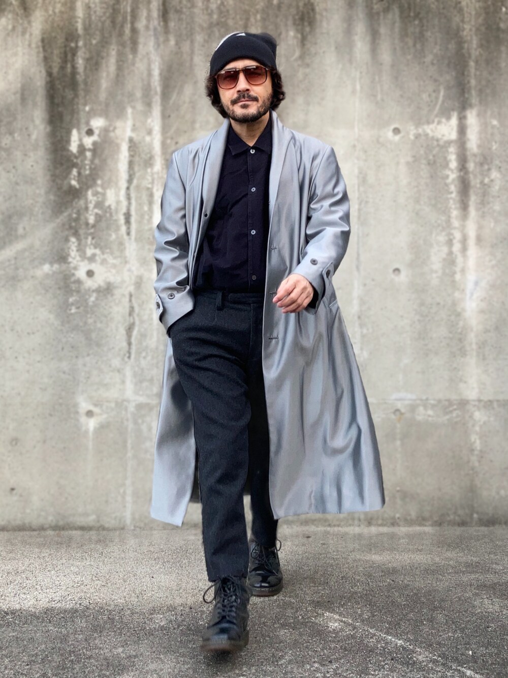 シルバー系のノーカラーコート、ブラック系のスラックス、ブラック系のブーツを着用したメンズの冬コーディネートの3枚目の写真