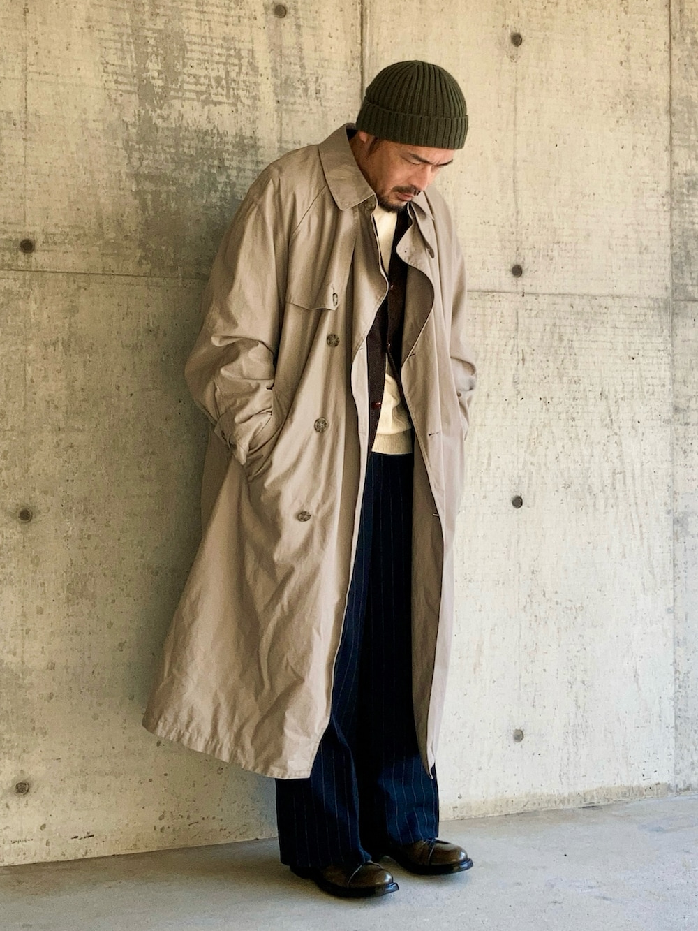 ブラウン系のテーラードジャケット、ベージュ系のトレンチコート、ブルー系のスラックスを着用したメンズの冬コーディネートの3枚目の写真