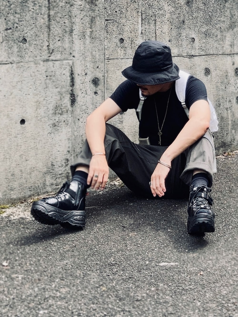 ブラック系のTシャツ/カットソー、グリーン系のその他パンツ、ブラック系のサンダルを着用したメンズの秋コーディネートの2枚目の写真