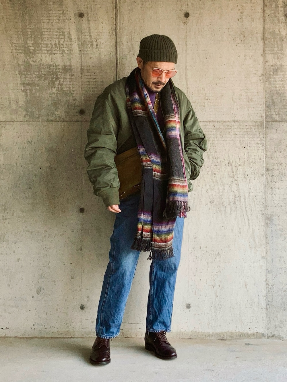 パープル系のスウェット、グリーン系のMA-1、ブルー系のデニムパンツを着用したメンズの冬コーディネートの3枚目の写真