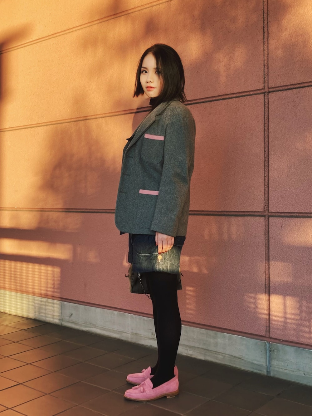 グレー系のテーラードジャケット、ブルー系のサロペット/オーバーオール、ピンク系のローファーを着用したレディースの秋コーディネートの2枚目の写真