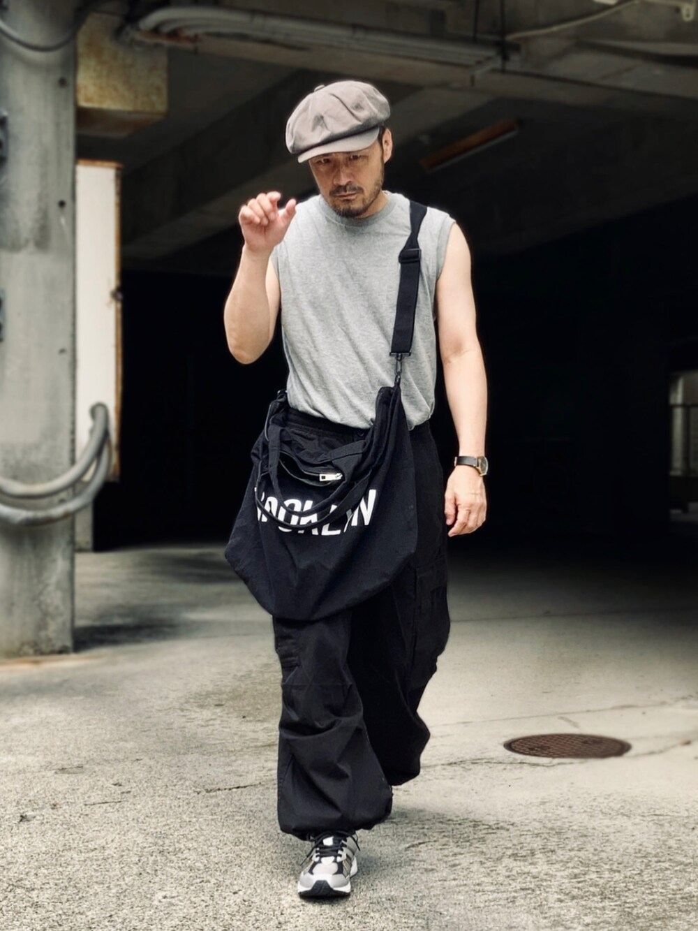 グレー系のTシャツ/カットソー、ブラック系のカーゴパンツ、ブラック系のスニーカーを着用したメンズの夏コーディネートの4枚目の写真