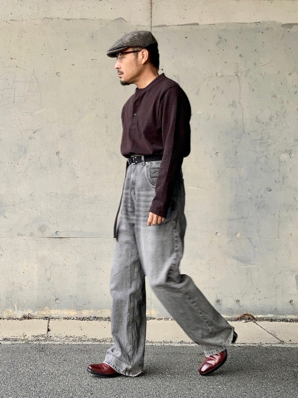 ブラウン系のTシャツ/カットソー、グレー系のデニムパンツ、レッド系のブーツを着用したメンズの秋コーディネートの4枚目の写真