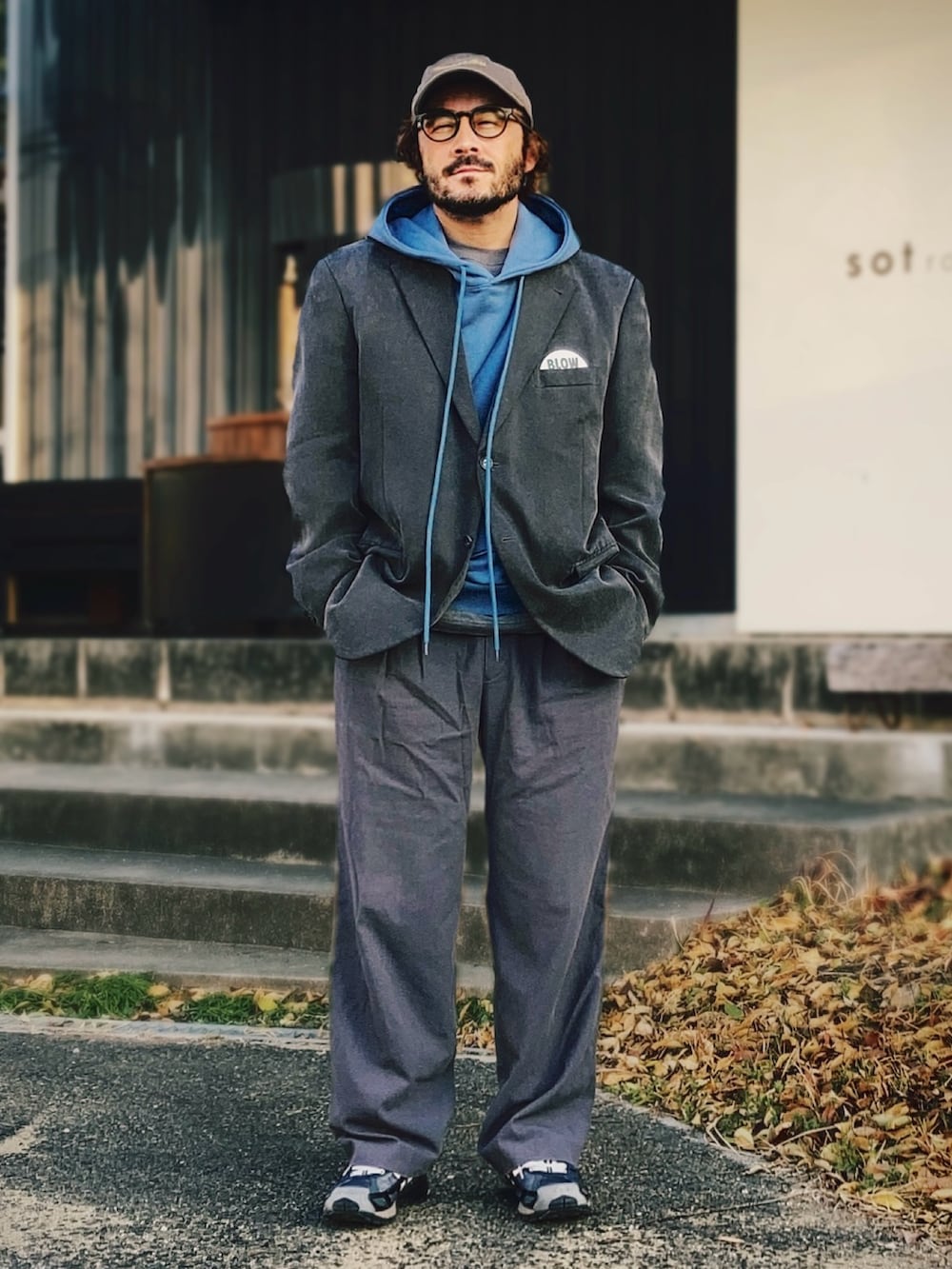 ブルー系のパーカー、グレー系のテーラードジャケット、グレー系のスラックスを着用したメンズの春コーディネートの2枚目の写真