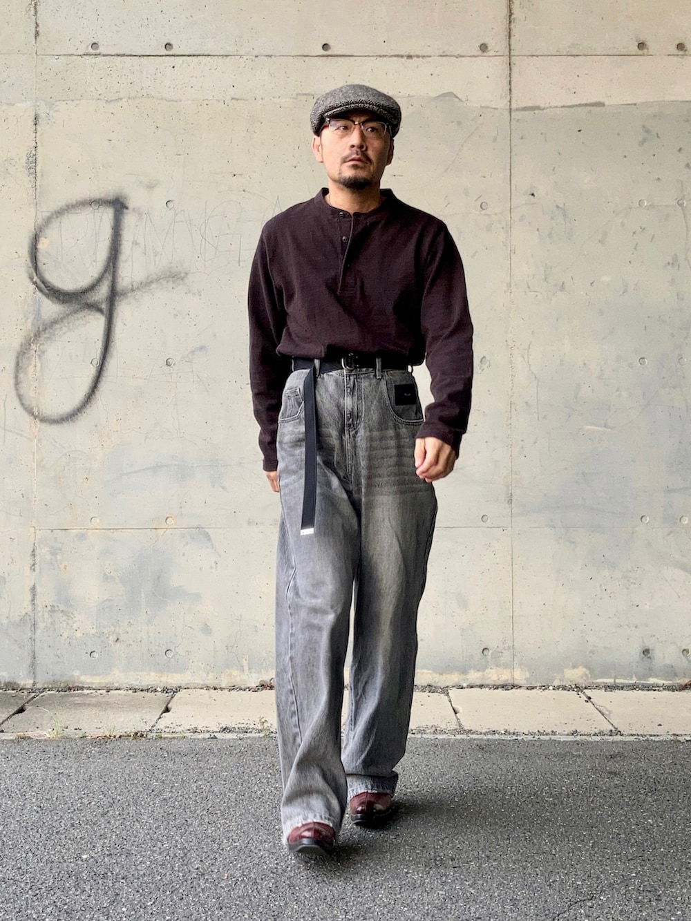 ブラウン系のTシャツ/カットソー、グレー系のデニムパンツ、レッド系のブーツを着用したメンズの秋コーディネートの2枚目の写真