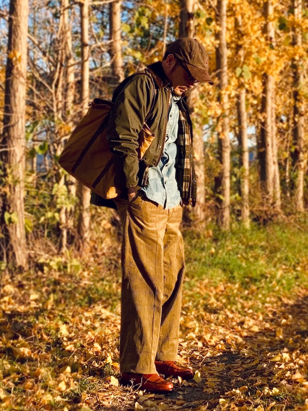 ブルー系のシャツ/ブラウス、ゴールド系のスラックス、ブラウン系のローファーを着用したメンズの冬コーディネートの2枚目の写真