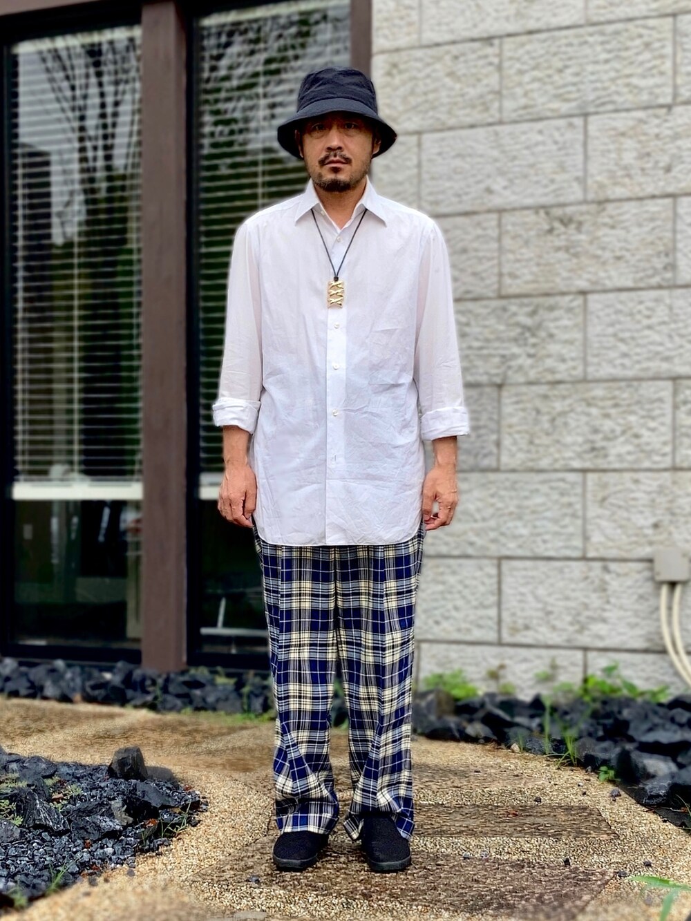 ホワイト系のシャツ/ブラウス、ブルー系のスラックス、ブラック系のスリッポンを着用したメンズの夏コーディネートの2枚目の写真