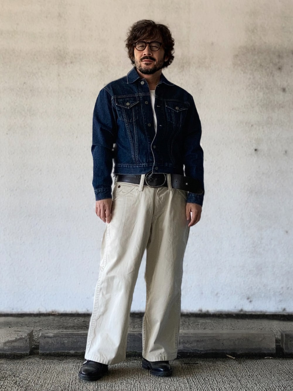 ブルー系のデニムジャケット、ホワイト系のデニムパンツ、ブラック系のドレスシューズを着用したメンズの春コーディネートの3枚目の写真