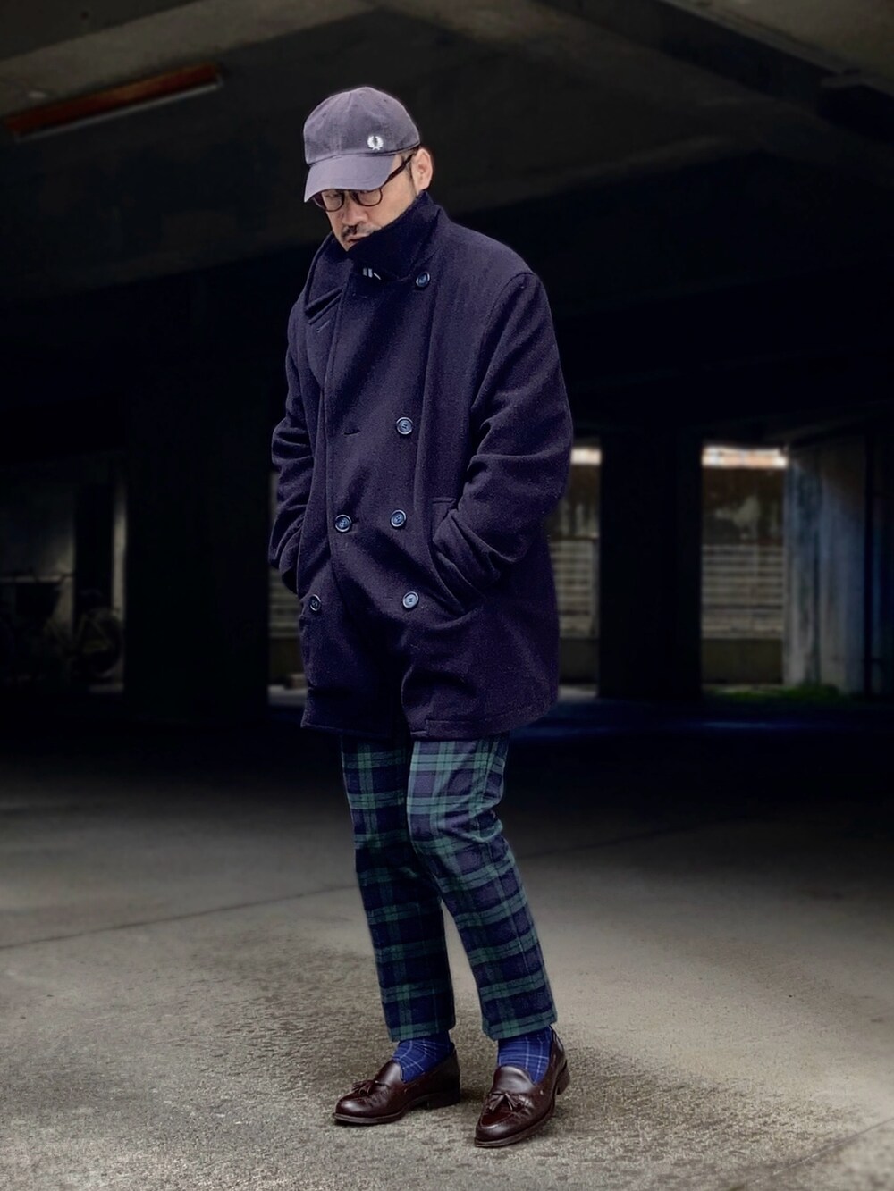 グレー系のニット/セーター、ブルー系のピーコート、グリーン系のスラックスを着用したメンズの冬コーディネートの3枚目の写真