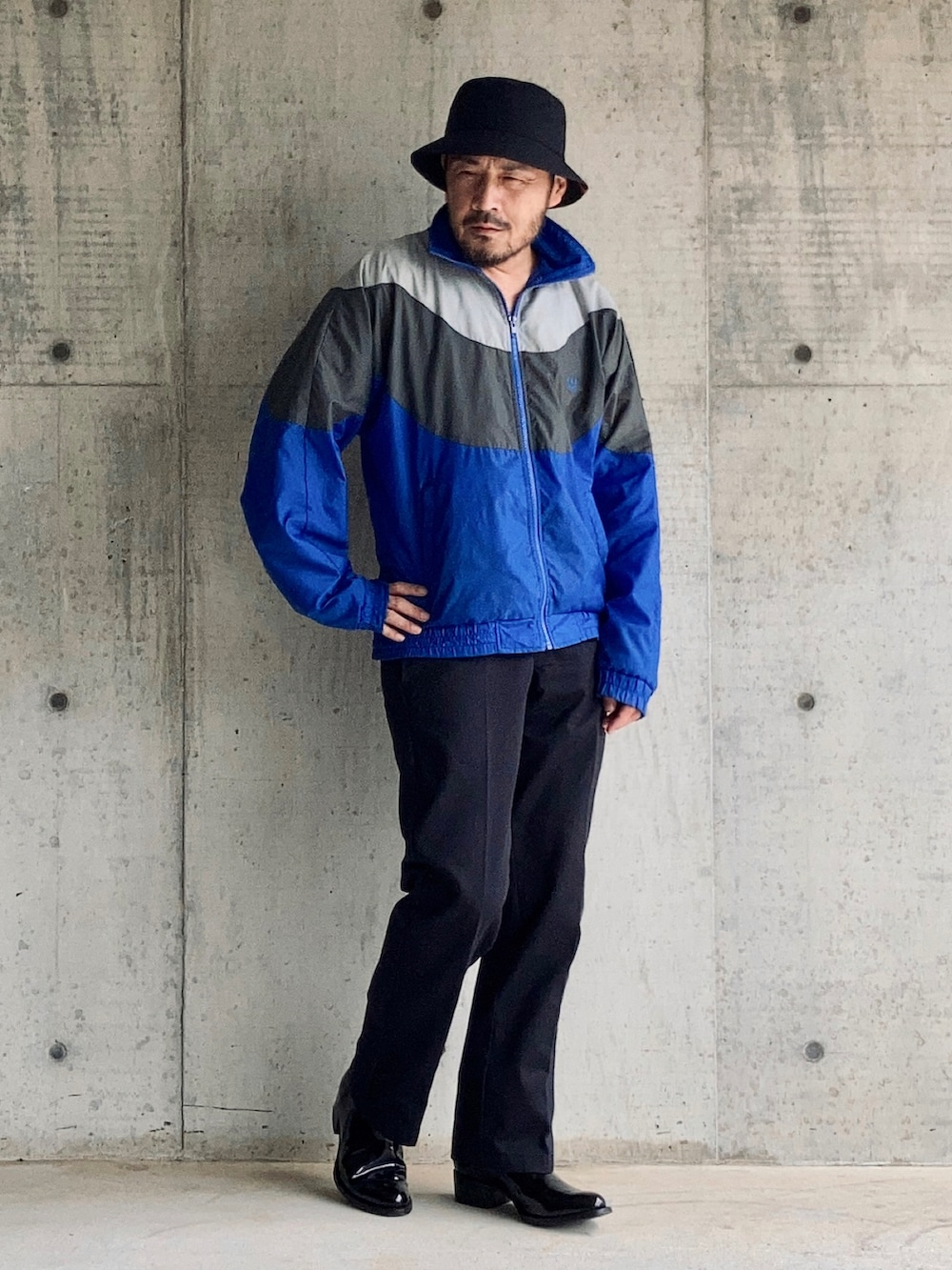ブルー系のナイロンジャケット、ブルー系のチノパンツ、ブラック系のブーツを着用したメンズの秋コーディネートの4枚目の写真