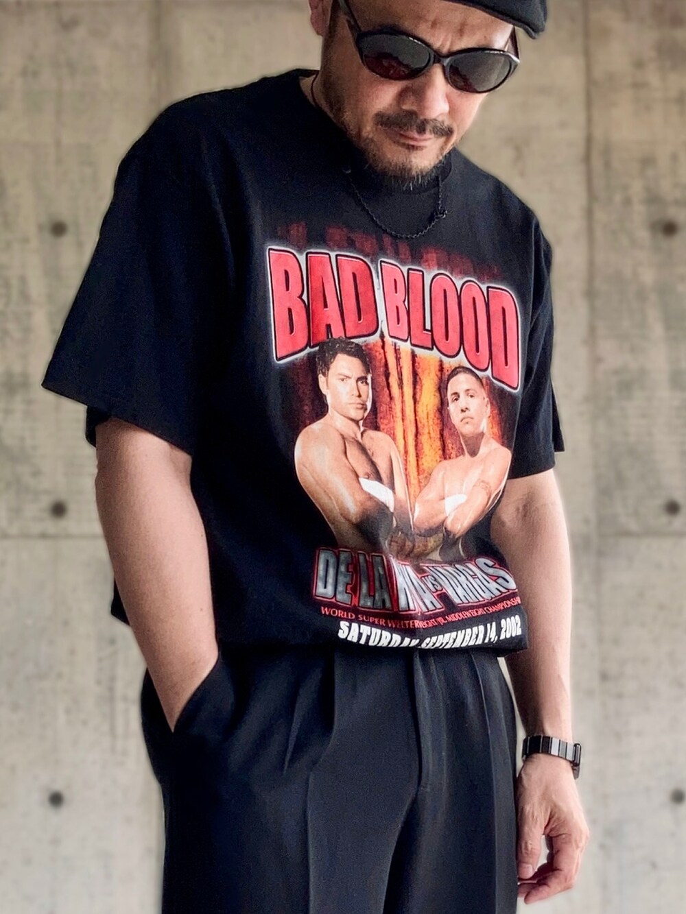 ブラック系のTシャツ/カットソー、ブラック系のスラックス、ブラック系のサンダルを着用したメンズの夏コーディネートの3枚目の写真