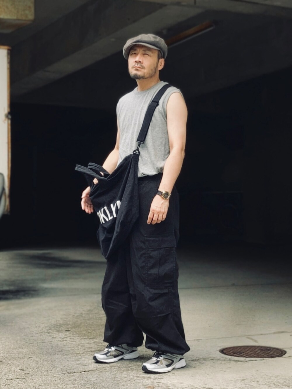 グレー系のTシャツ/カットソー、ブラック系のカーゴパンツ、ブラック系のスニーカーを着用したメンズの夏コーディネートの3枚目の写真