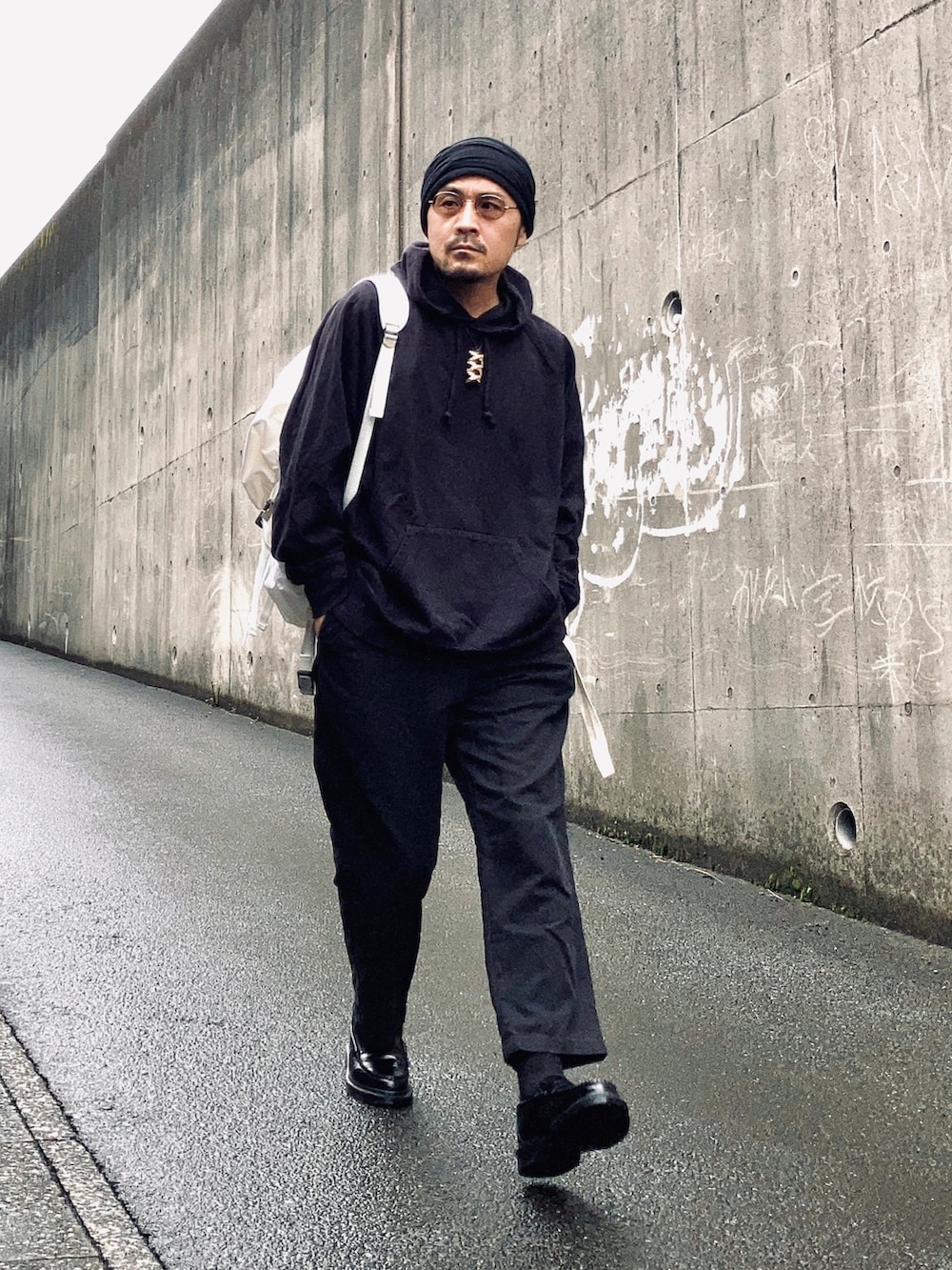 ブラック系のパーカー、ブラック系のその他パンツ、ブラック系のローファーを着用したメンズの秋コーディネートの5枚目の写真