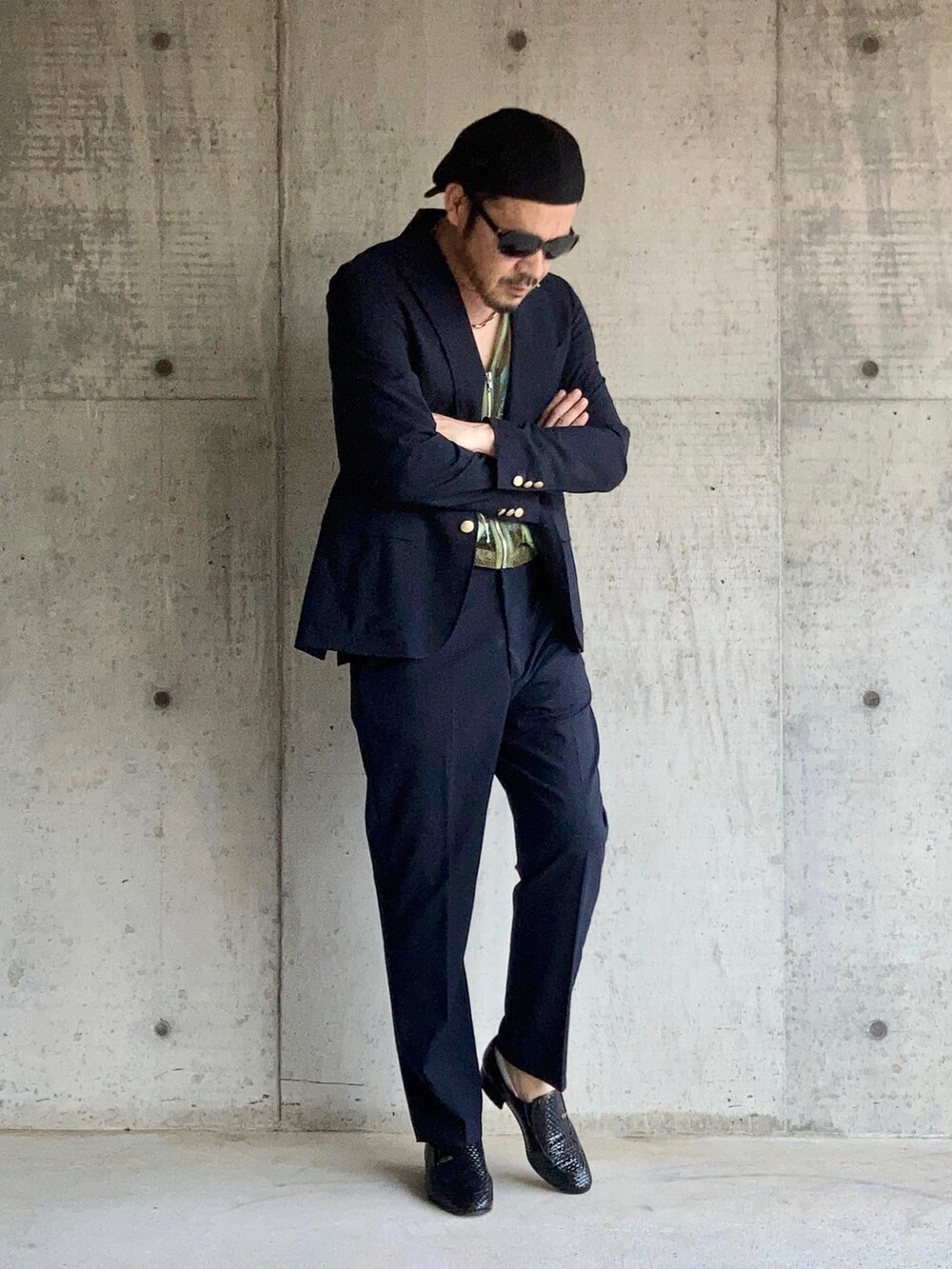 グリーン系のベスト、ブルー系のタンクトップ、ブルー系のテーラードジャケットを着用したメンズの秋コーディネートの2枚目の写真