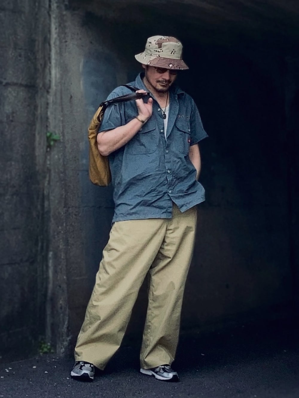 ベージュ系のチノパンツ、グリーン系のシャツ/ブラウス、ブラック系のスニーカーを着用したメンズの春コーディネートの2枚目の写真