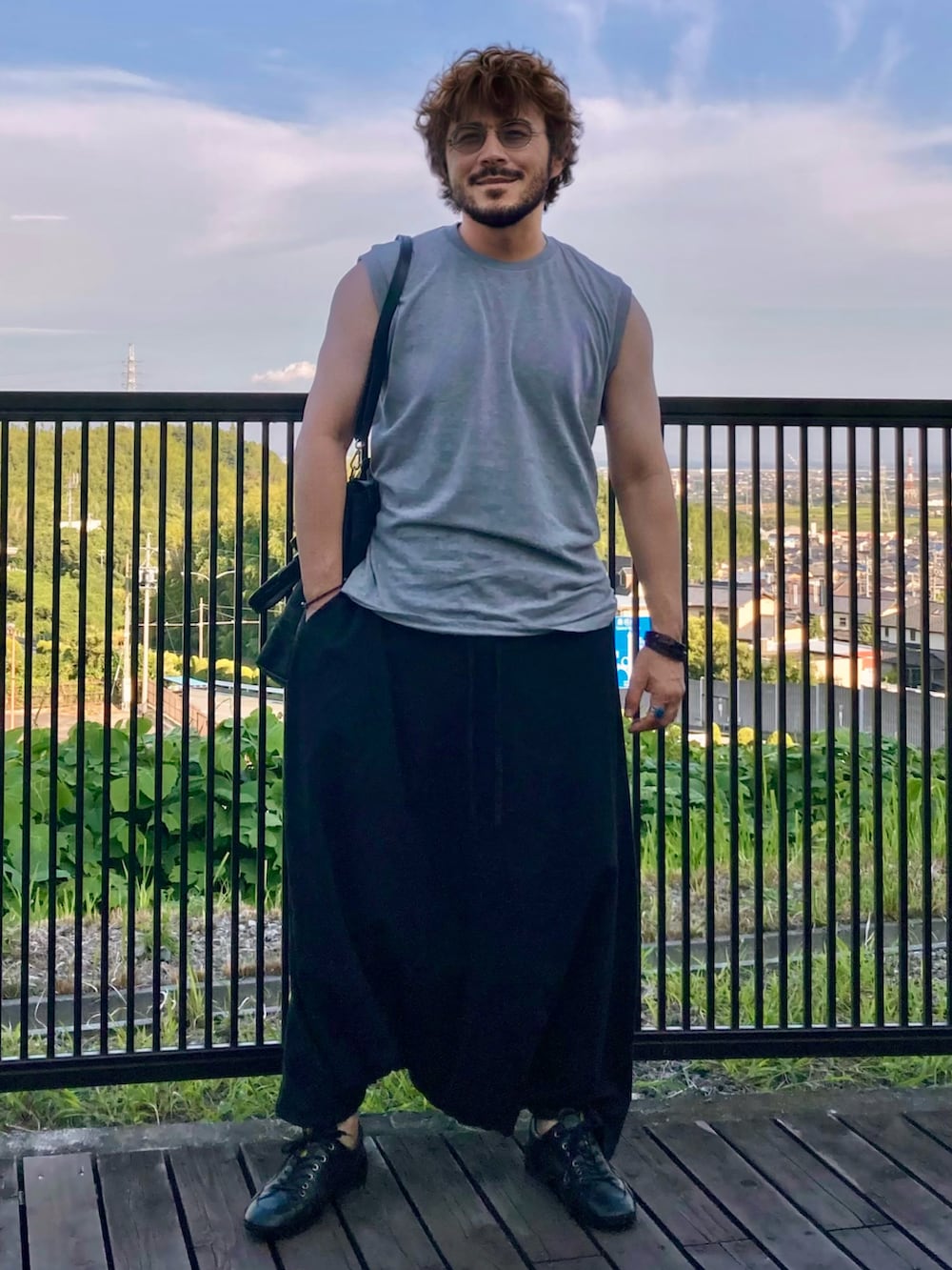 グレー系のTシャツ/カットソー、ブラック系のその他パンツ、ブラック系のトートバッグを着用したメンズの夏コーディネートの2枚目の写真