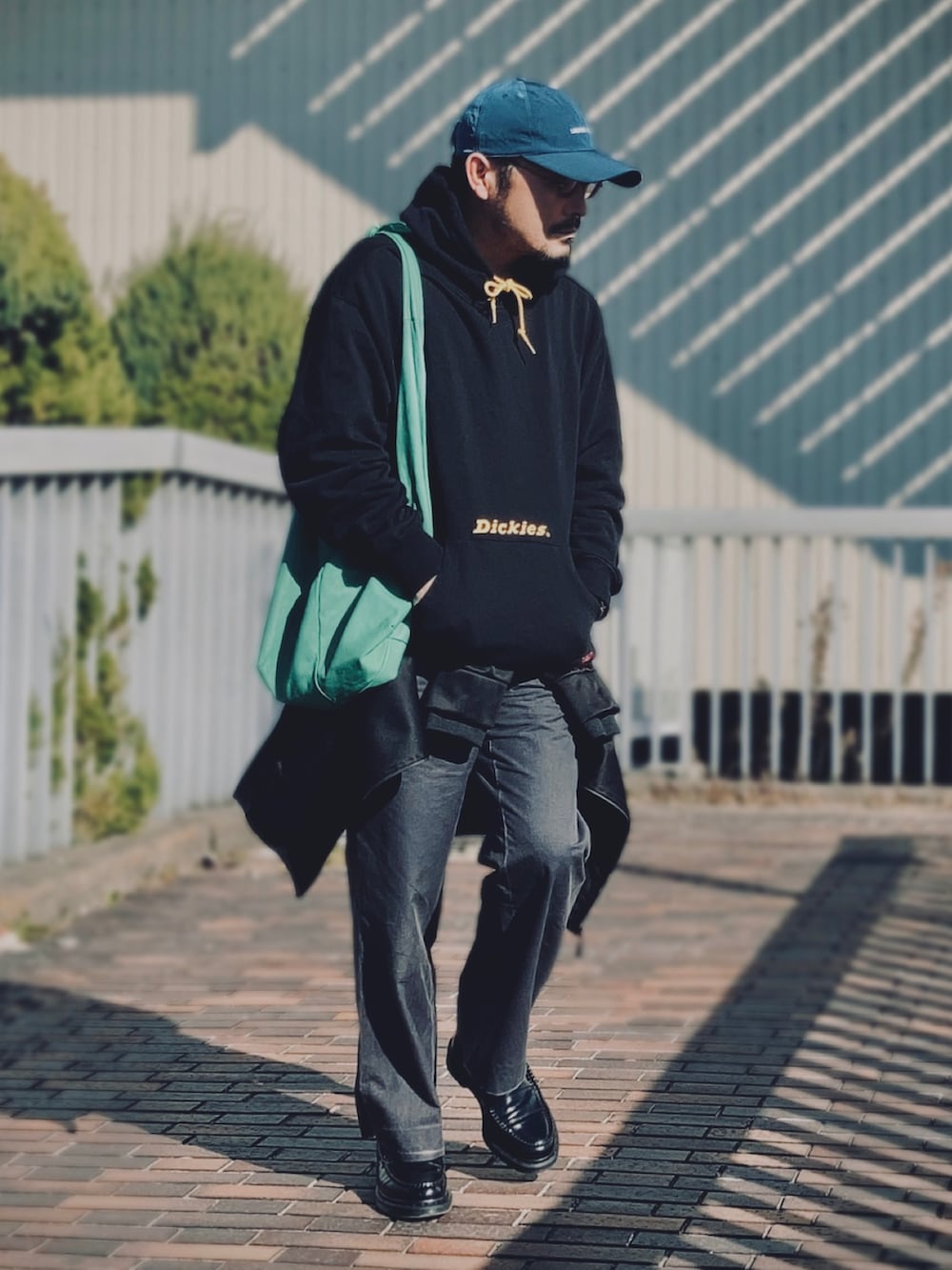 ブラック系のパーカー、ブラック系のジャケット/アウター、グレー系のスラックスを着用したメンズの冬コーディネートの2枚目の写真