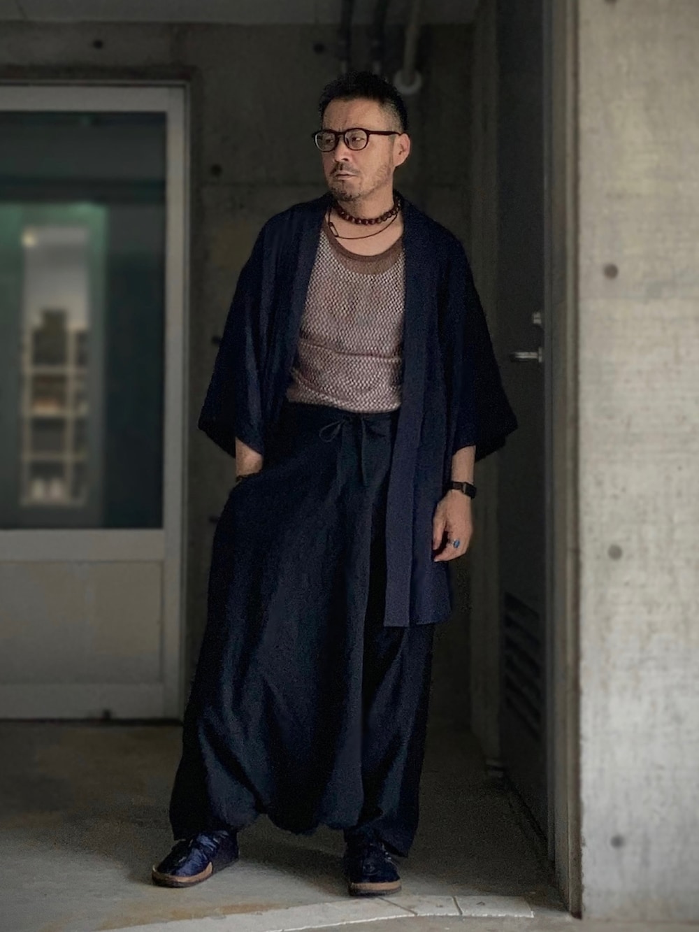 ブラウン系のタンクトップ、ホワイト系のタンクトップ、ブラック系のその他パンツを着用したメンズの夏コーディネートの3枚目の写真