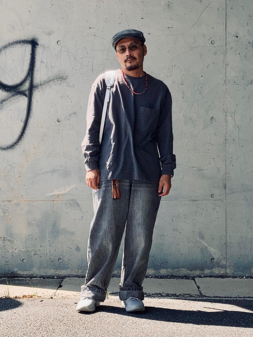 グレー系のTシャツ/カットソー、グレー系のデニムパンツ、グレー系のスニーカーを着用したメンズの秋コーディネートの3枚目の写真