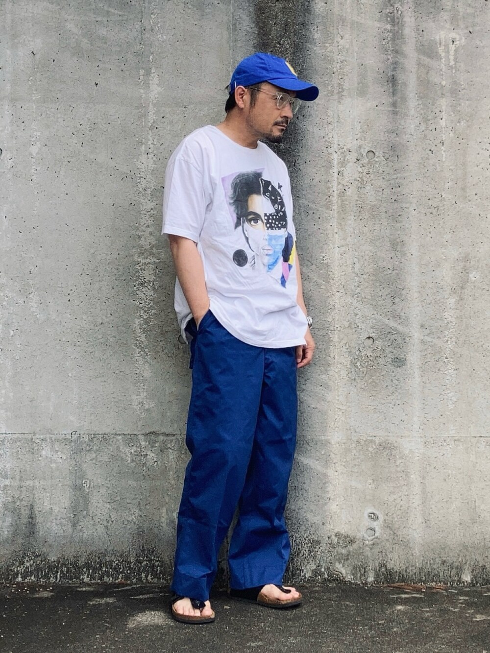 ホワイト系のTシャツ/カットソー、ブルー系のその他パンツ、ブラック系のサンダルを着用したメンズの夏コーディネートの3枚目の写真