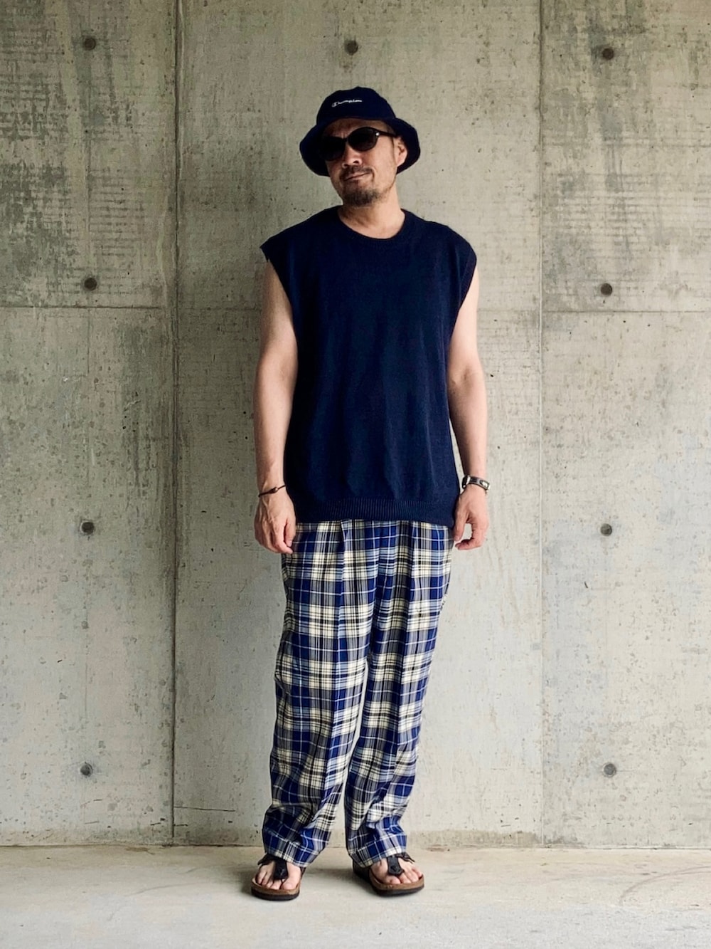 ブルー系のベスト、ブルー系のスラックス、ブラック系のサンダルを着用したメンズの夏コーディネートの3枚目の写真