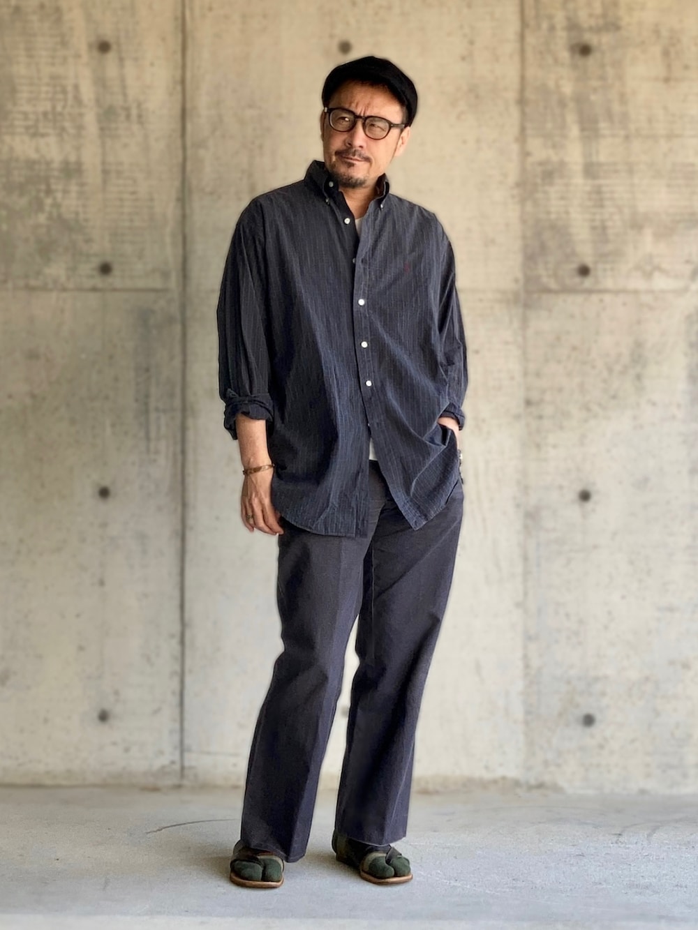 ホワイト系のTシャツ/カットソー、グリーン系のシャツ/ブラウス、グレー系のスラックスを着用したメンズの春コーディネートの3枚目の写真