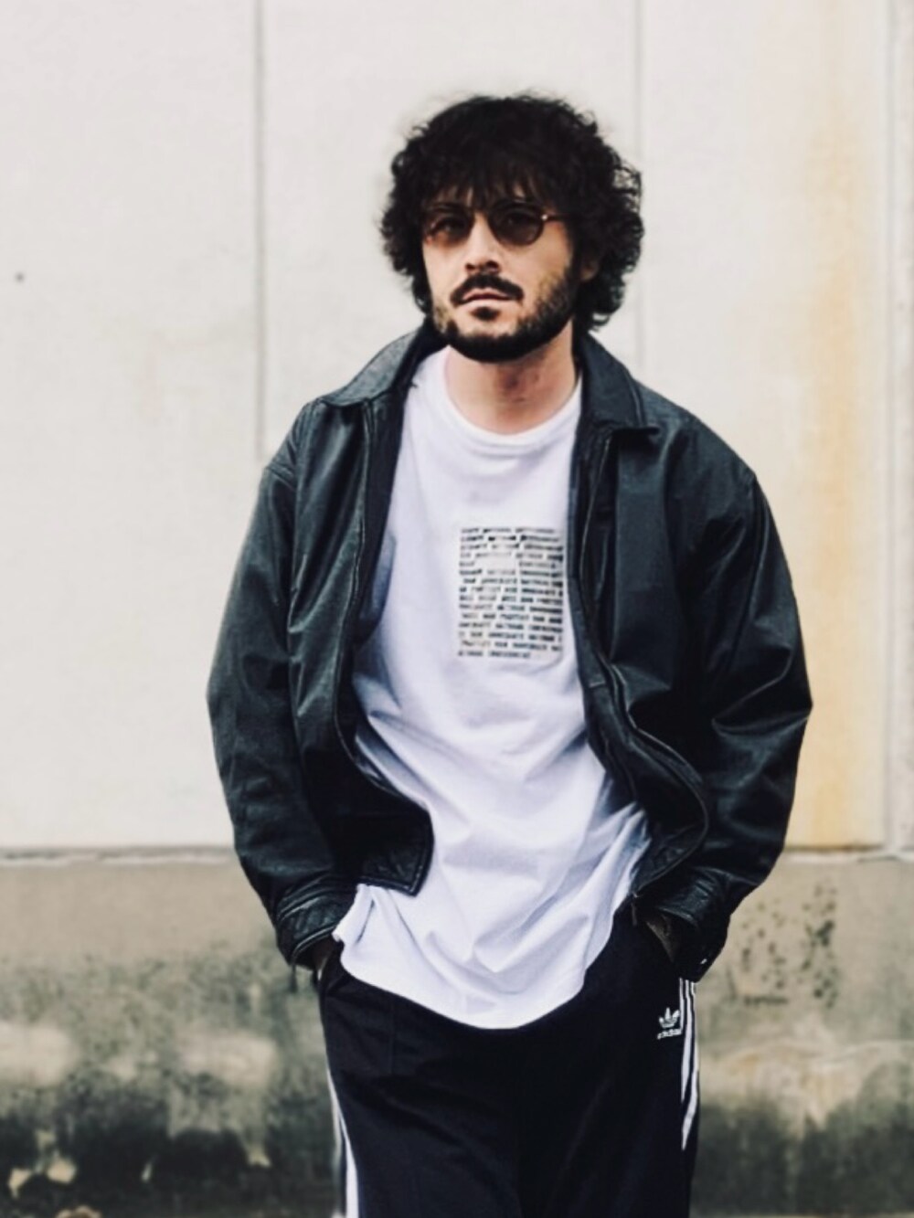 ホワイト系のTシャツ/カットソー、ブラック系のブルゾン、ブラック系のスウェットパンツを着用したメンズの秋コーディネートの3枚目の写真