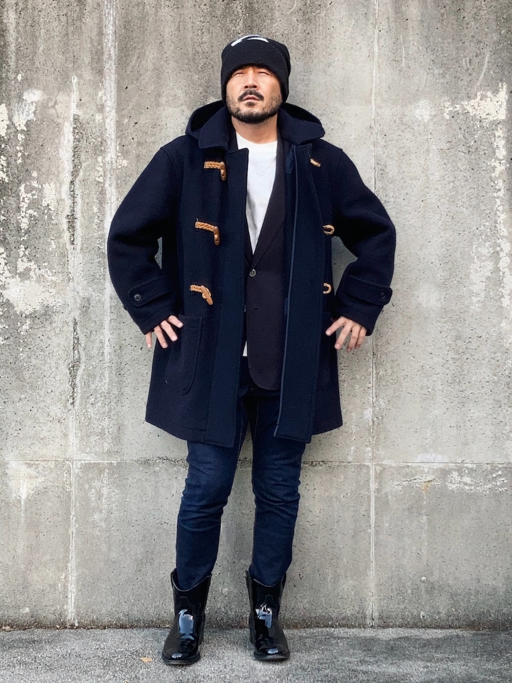 ブラック系のテーラードジャケット、ブルー系のダッフルコート、ブルー系のデニムパンツを着用したメンズの秋コーディネートの2枚目の写真